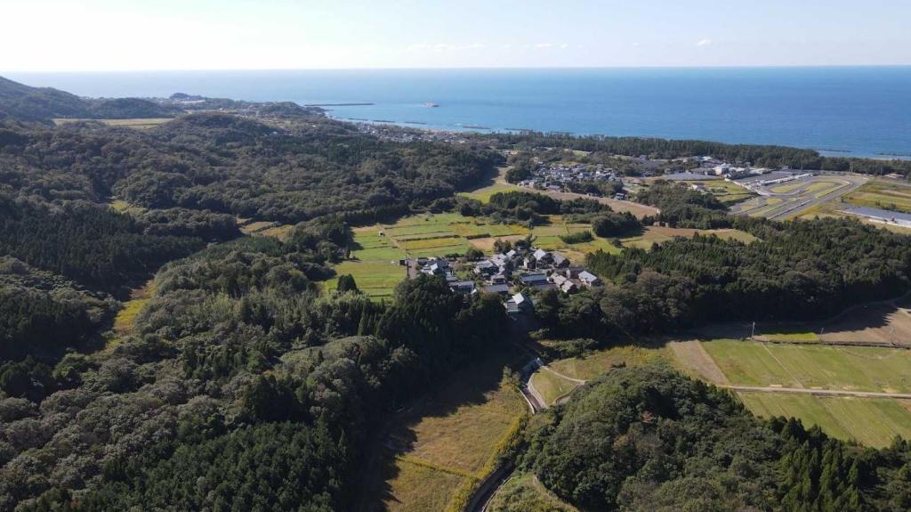 una vista aérea de una casa en una colina junto al océano en Auberge Fujii Fermier en Fukui