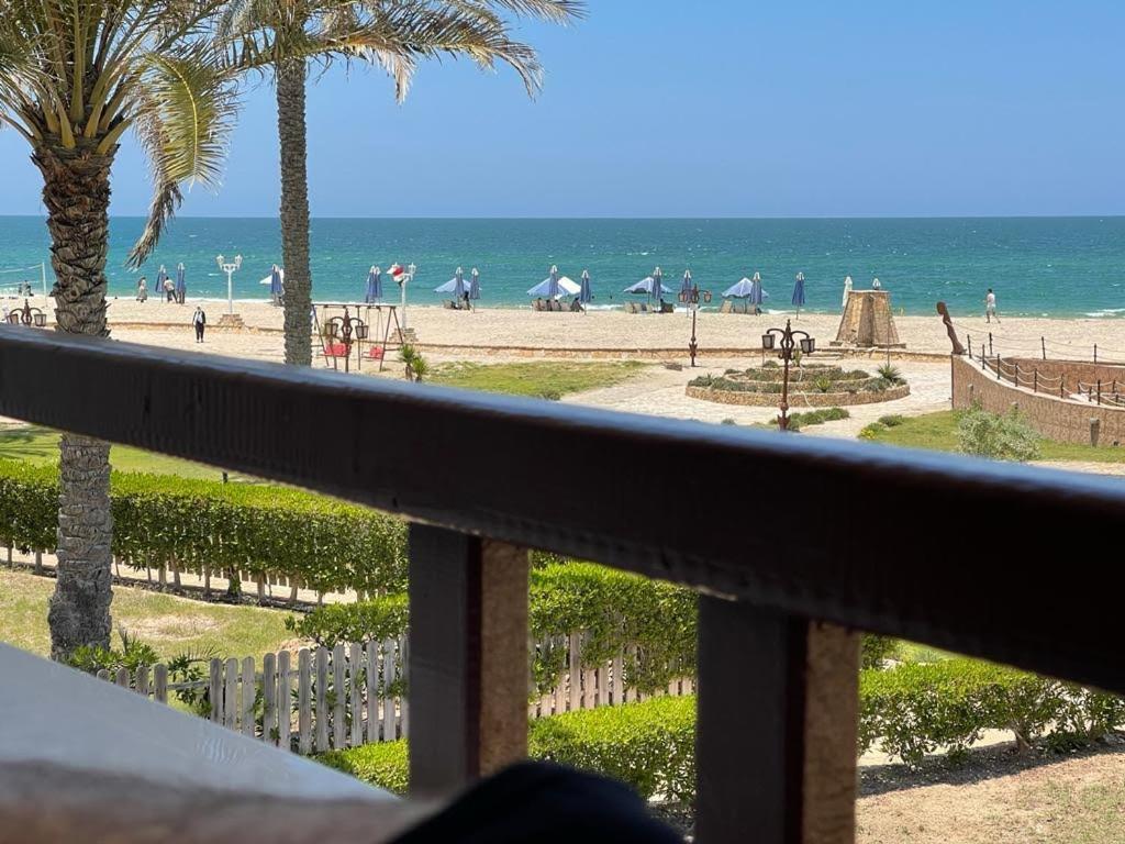 uma vista para a praia a partir de uma varanda em Villa, Sea Front View منتجع قرية سما العريش em El Arish