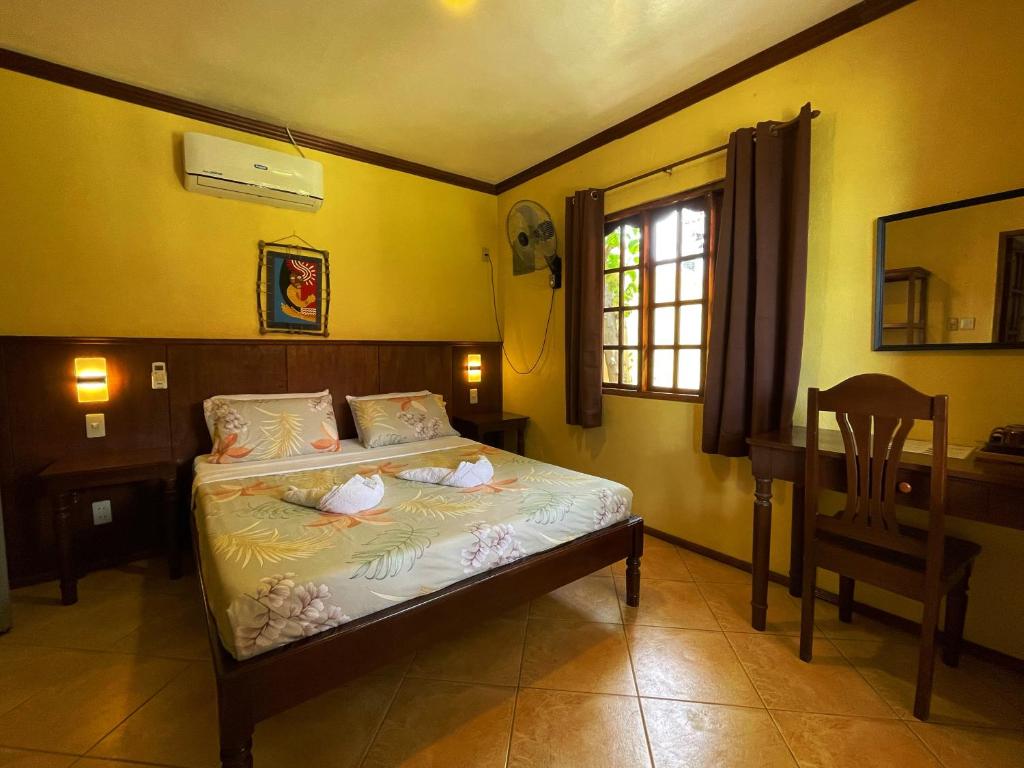 una camera con letto, scrivania e sedia di Tipolo Beach Resort a Moalboal