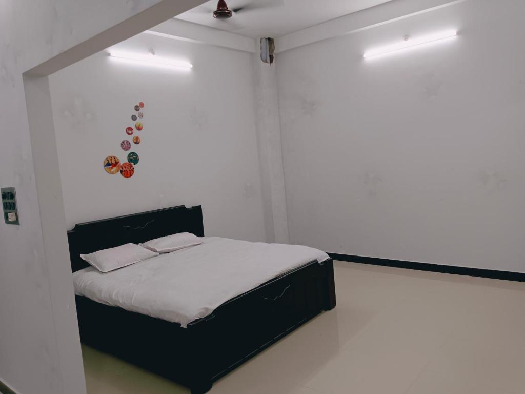 a bedroom with a bed in a white room at Narayan nivas homestay in Ujjain
