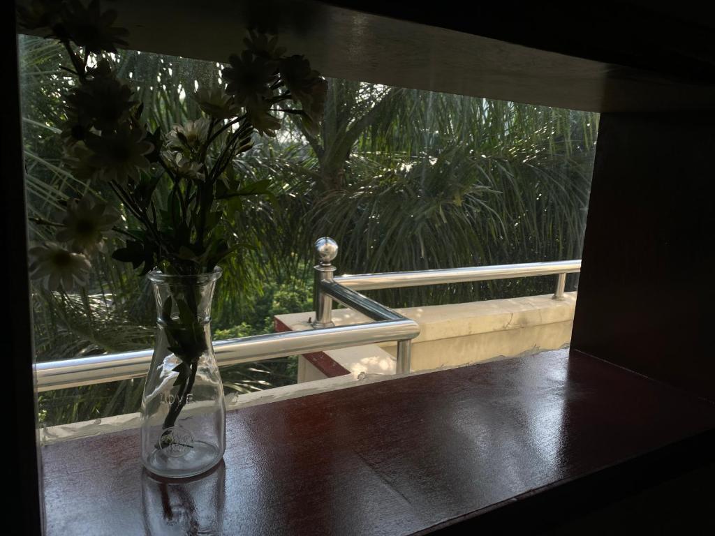 un jarrón lleno de flores sentado en una mesa en Oasis Appartment, en Hải Dương