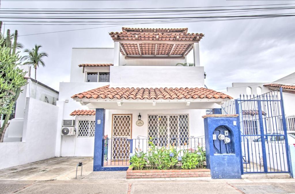 a house with a blue gate in front of it at Las Palmas Golden Zone Duplex - Pool & Sunset Rooftop in Bucerías