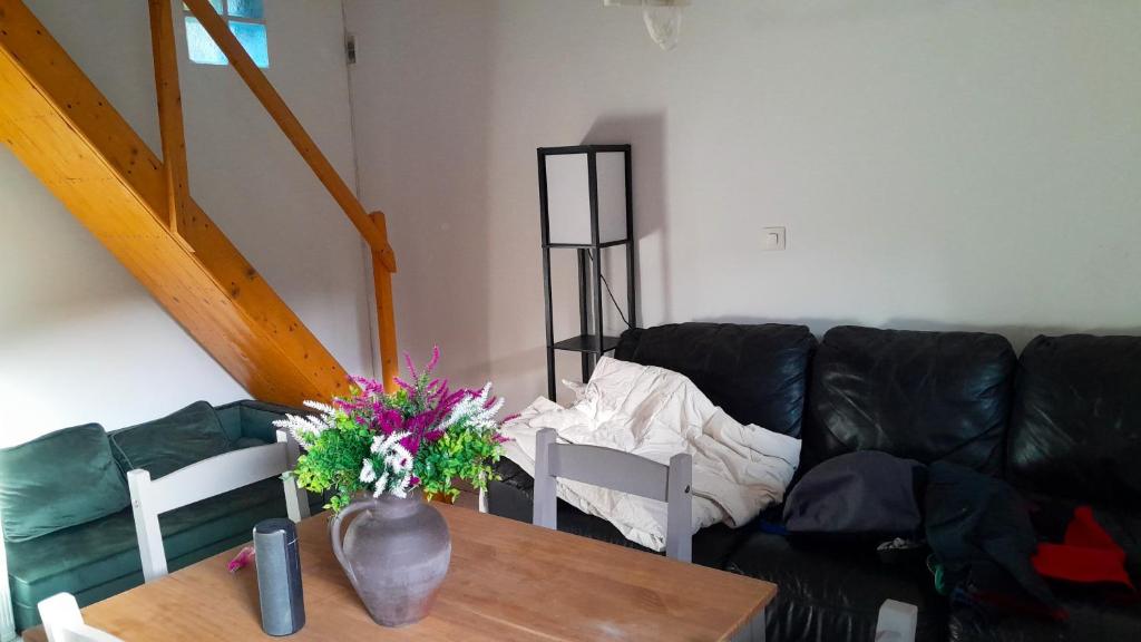 un salon avec un canapé et une table avec des fleurs dans l'établissement Studio confortable avec piscine privée à Vassens - 16 m², à Tartiers