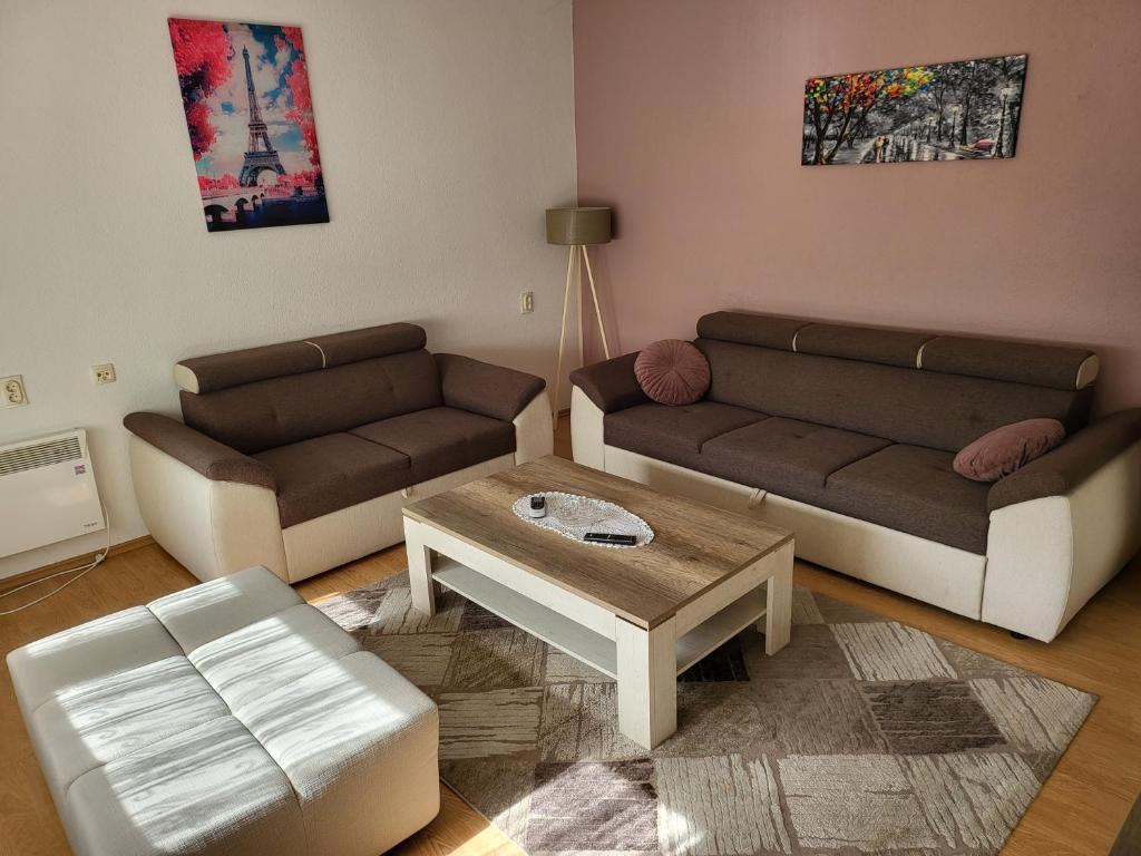 a living room with two couches and a coffee table at Stan u centru Prnjavor in Prnjavor