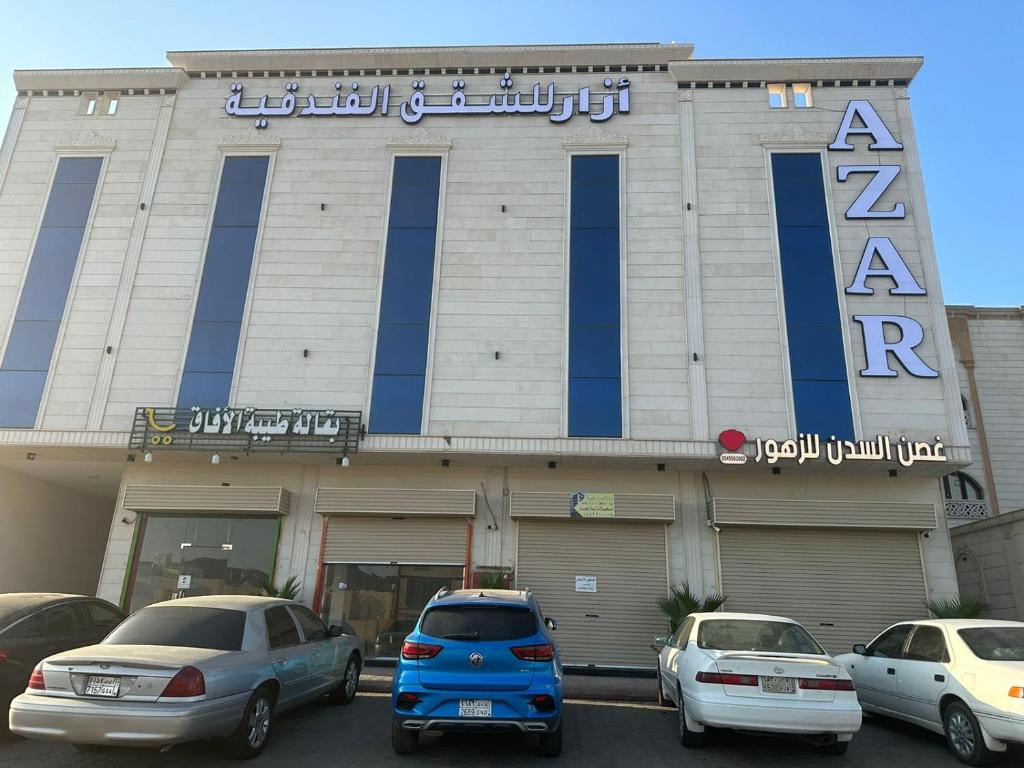 un edificio con coches estacionados frente a él en أزار للشقق الفندقية, en Abyār ‘Alī