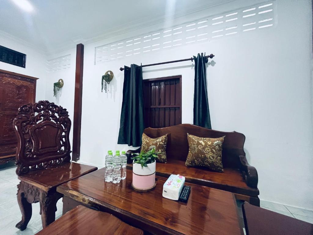 a living room with a wooden table and a bench at The Picnic House Battambang in Battambang