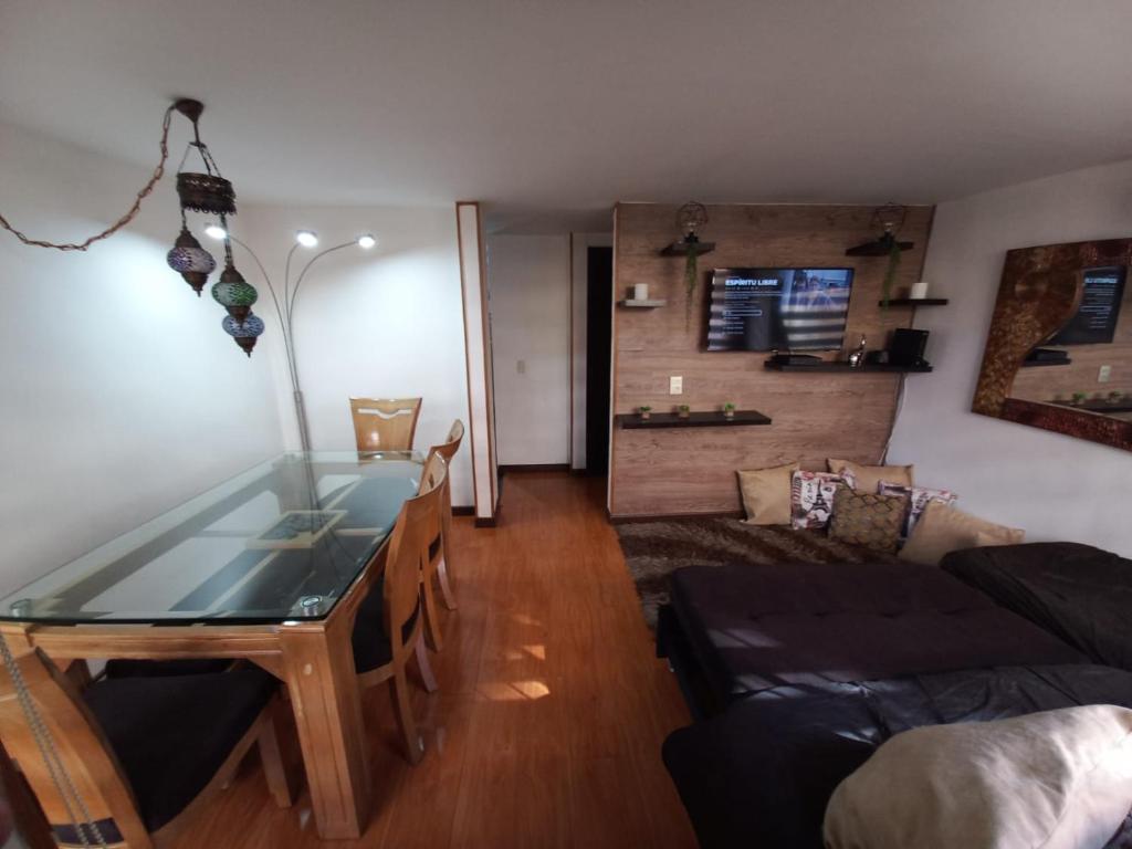 uma sala de estar com uma mesa de vidro e um sofá em Casa amoblada en Colina Campestre em Bogotá