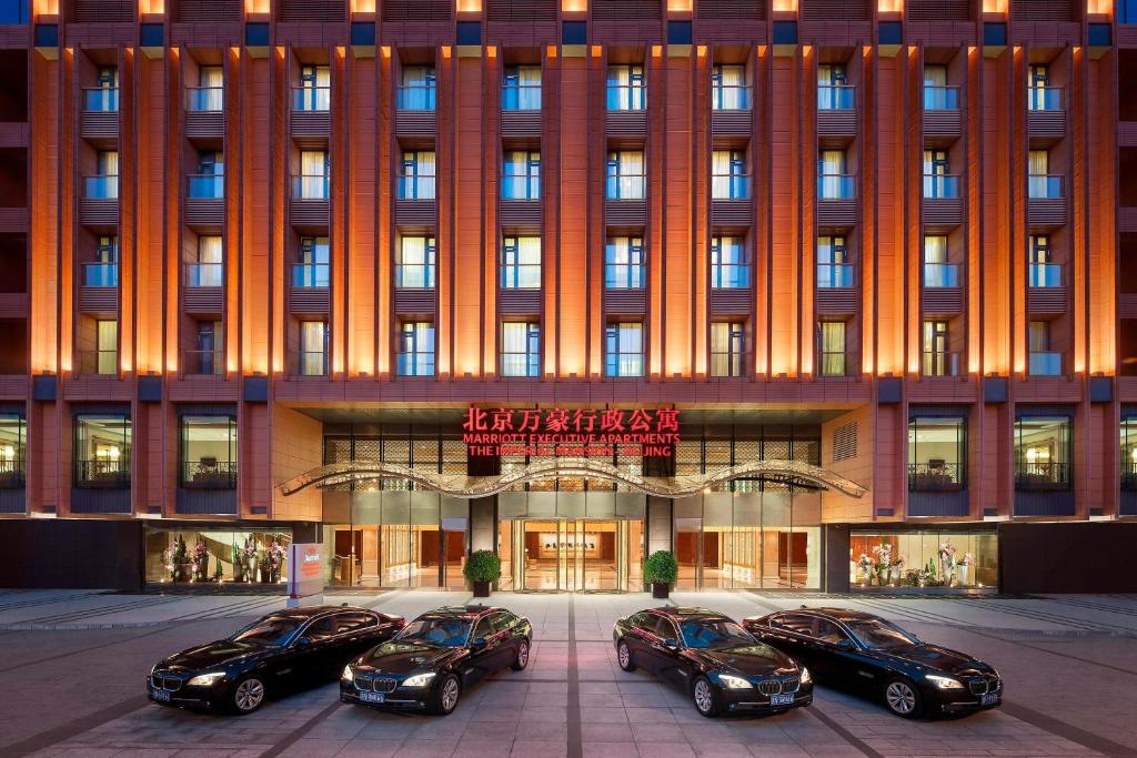 cuatro coches estacionados frente a un edificio en The Imperial Mansion, Beijing - Marriott Executive Apartments, en Beijing