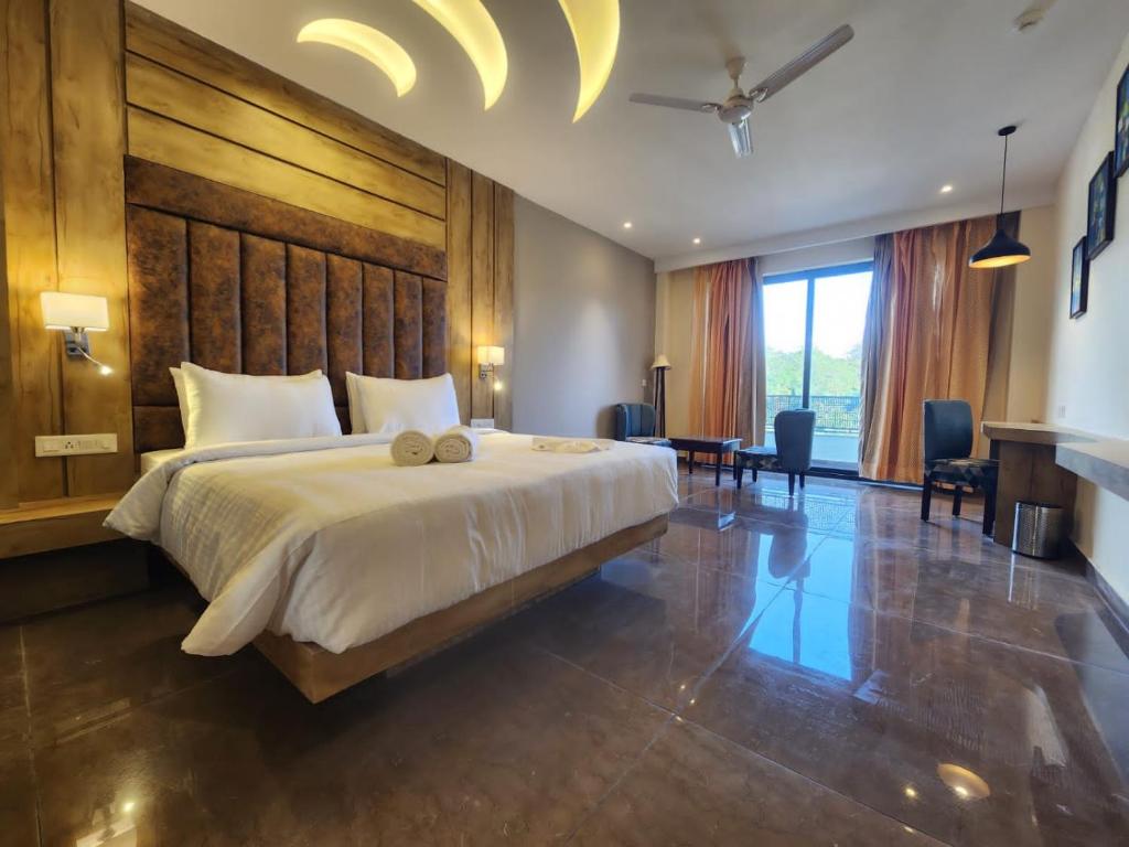 a bedroom with a large bed with a large wooden headboard at Portola Hotel By Parkside in Dharamshala