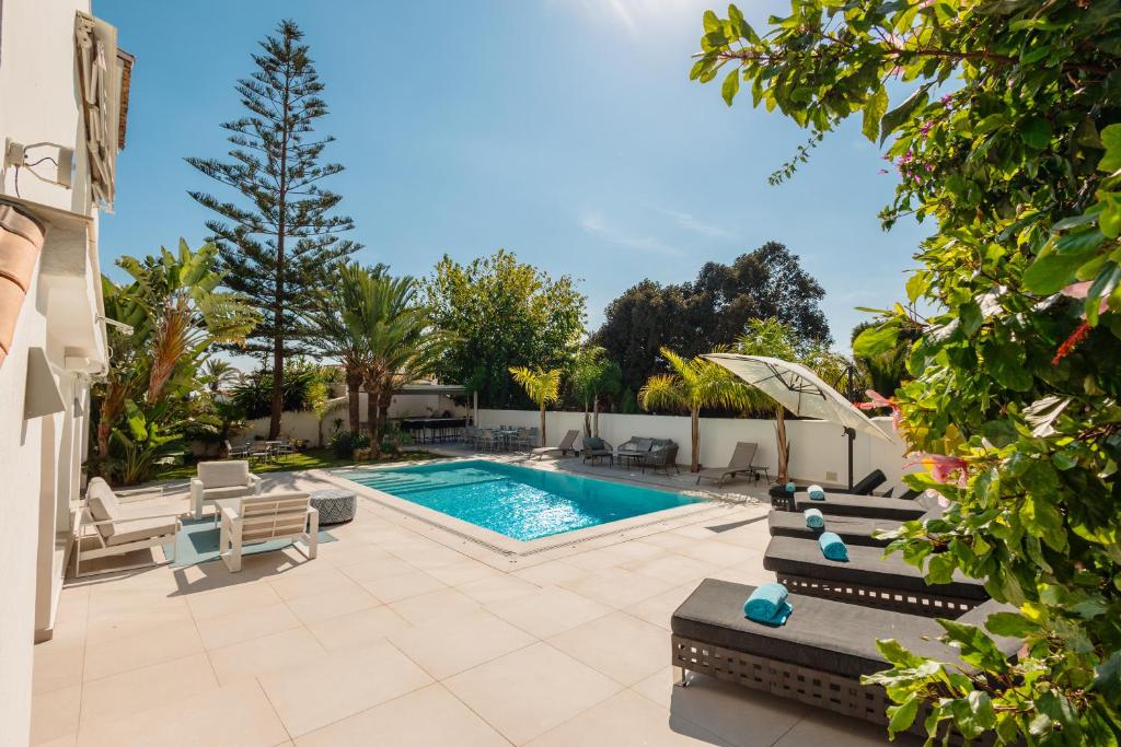 basen z leżakami i basen w obiekcie 6 bedroom villa, with heated pool and sea views, next to the beach of Costabella w Marbelli