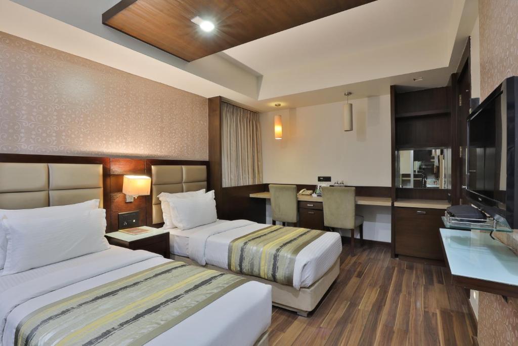 Postel nebo postele na pokoji v ubytování Krios Hotel - Near SG Highway, Ahmedabad