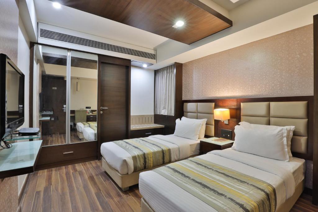 Postel nebo postele na pokoji v ubytování Krios Hotel - Near SG Highway, Ahmedabad