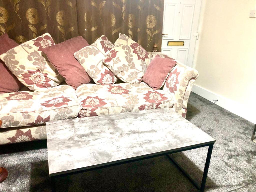 un sofá con almohadas en la sala de estar en AC Lounge 115 en Rochford