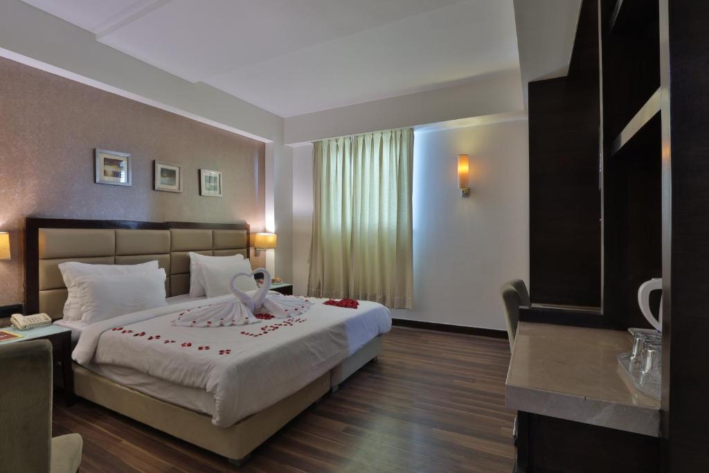 Postel nebo postele na pokoji v ubytování Krios Hotel - Near SG Highway, Ahmedabad