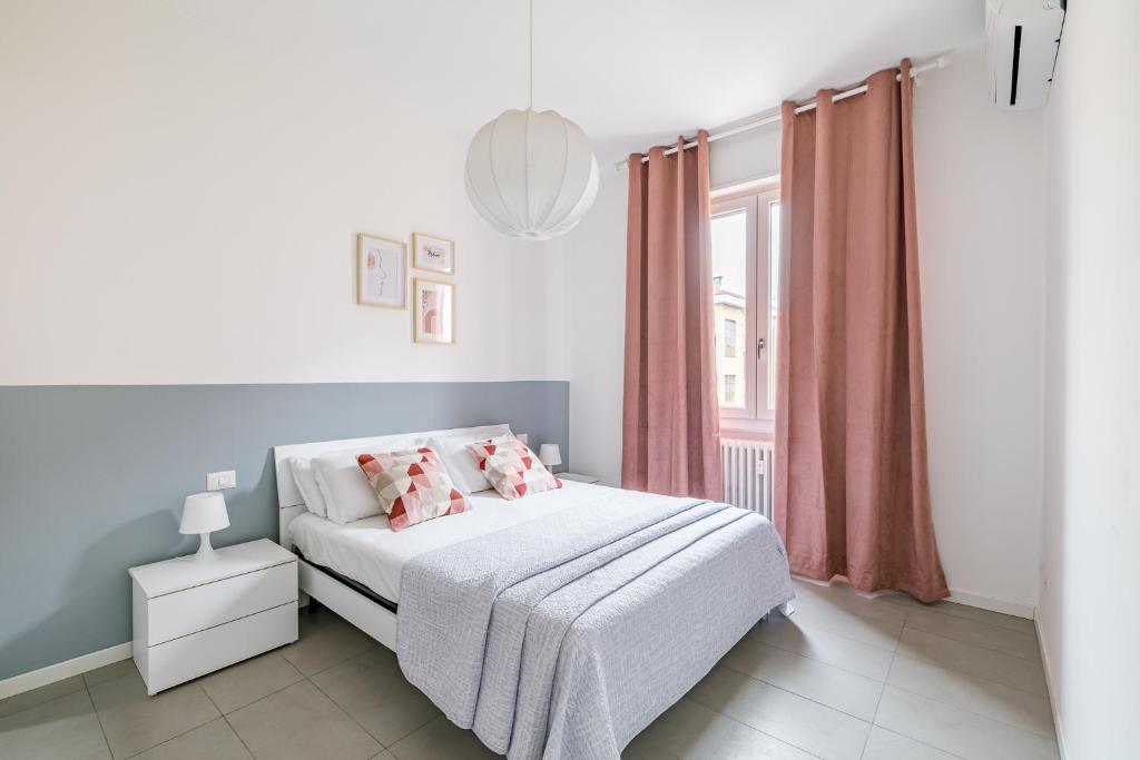 Habitación blanca con cama y ventana en Casa di Lolli, en Milán