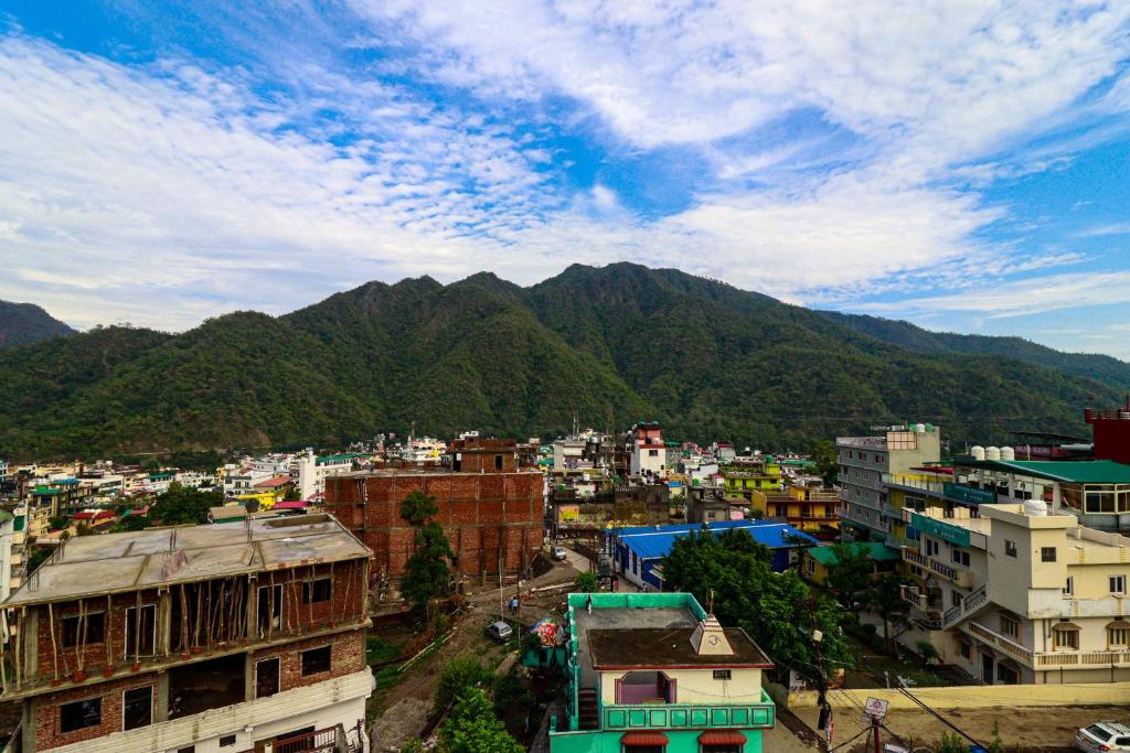 Blick auf eine Stadt mit Bergen im Hintergrund in der Unterkunft Manzil Hostel in Rishikesh