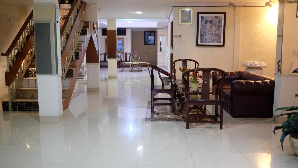 a hallway with chairs and stairs in a house at Zen Boutique Syariah Hotel in Jakarta