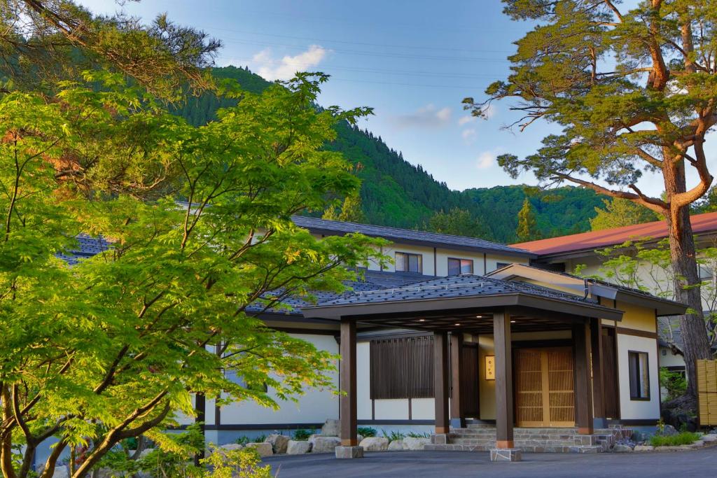 uma casa nas montanhas com árvores em Yukemuri no Yado Inazumi Onsen em Yuzawa