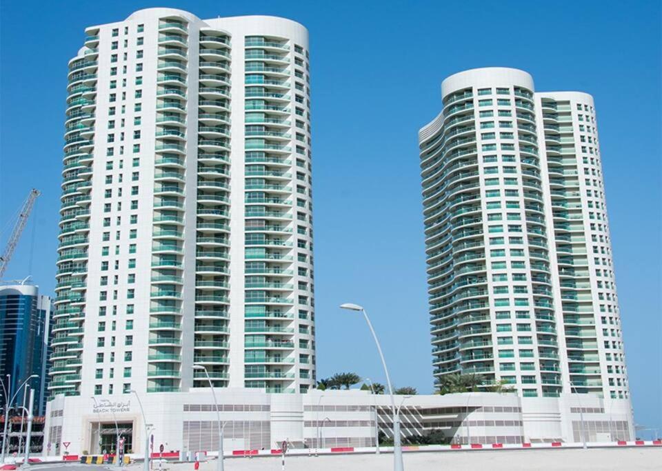 zwei hohe weiße Gebäude in einer Stadt in der Unterkunft Beachfront Haven Bliss 2801A in Abu Dhabi