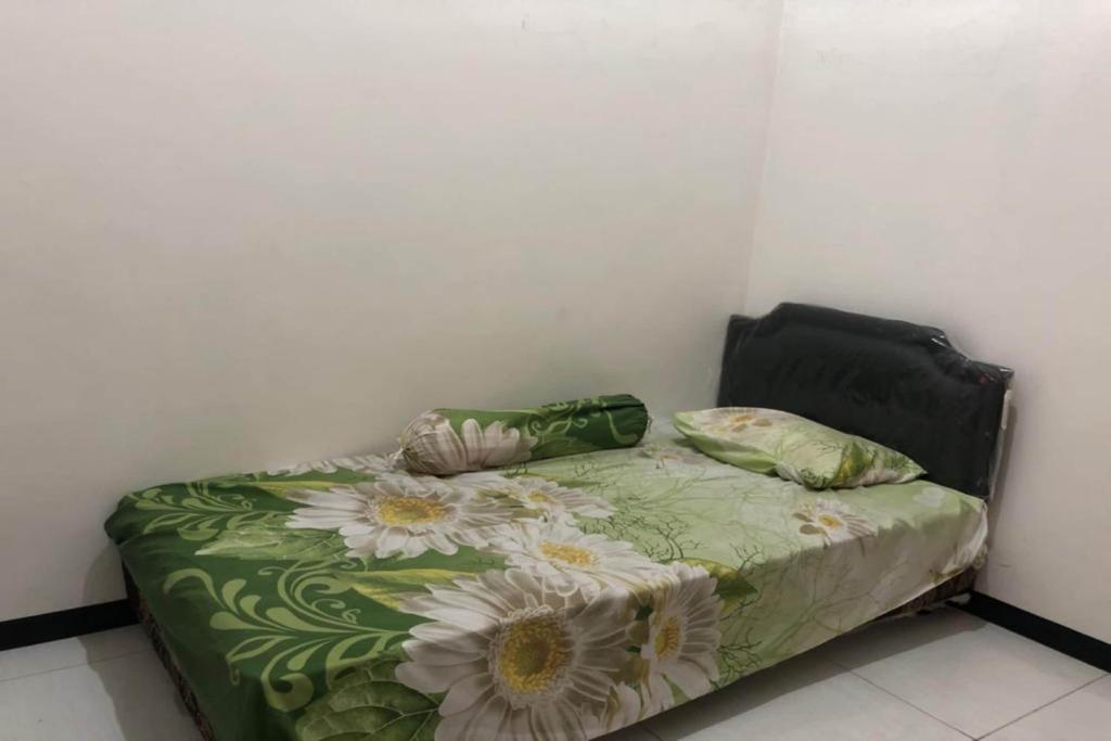 un letto con due cuscini sopra in una stanza di OYO Life 2678 Manyar Guest House a Surabaya
