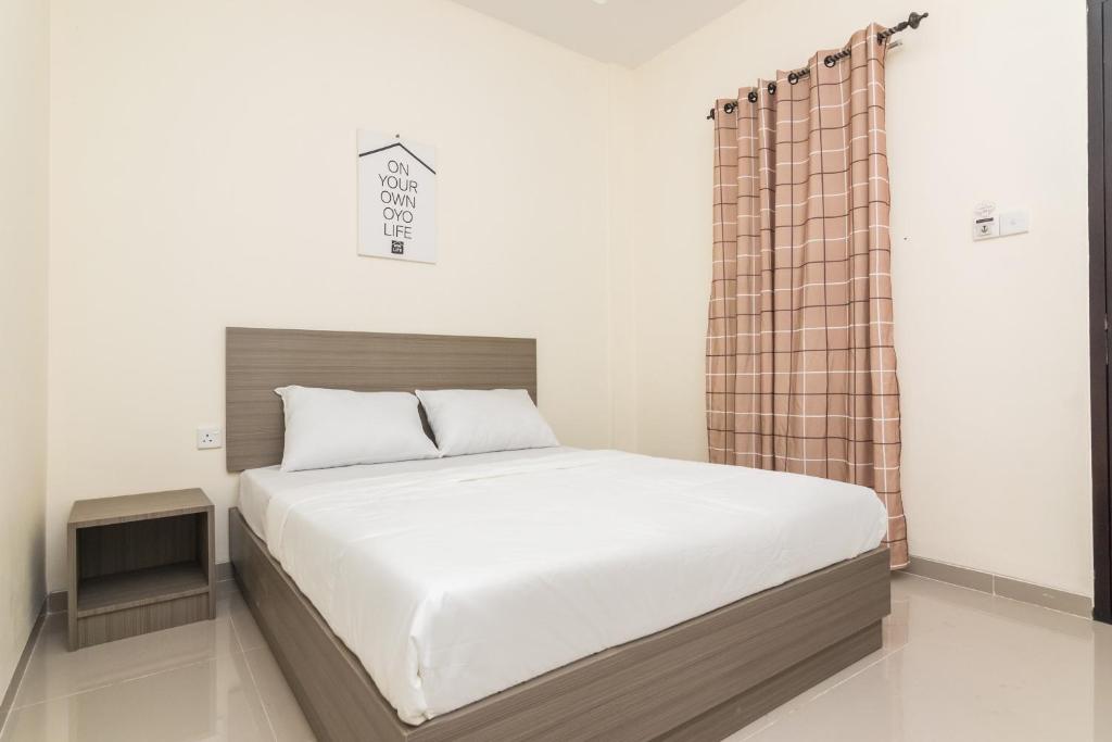 1 dormitorio con cama grande y cortina en OYO Life 2735 Graha Nirwana en Tanjungriau