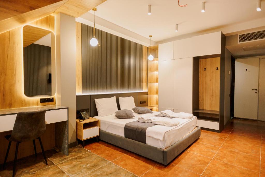 um quarto com uma cama, uma secretária e uma televisão em Bel Mare Boutique Hotel em Batumi