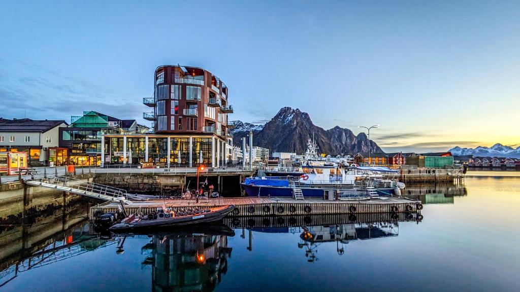 a marina with boats in the water and a building at Nordis Apartments in Svolvær