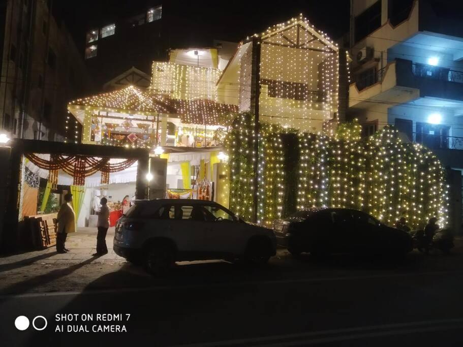 a building covered in lights with a car parked in front at Great Spacious Villa with Courtyard Gardens in Hyderabad