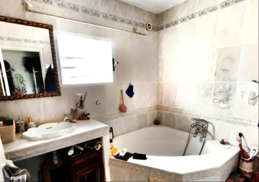 bagno con vasca, lavandino e specchio di Maison de charme, en Plaine Poésie -chez l'habitant- a La Plaine-des-Palmistes