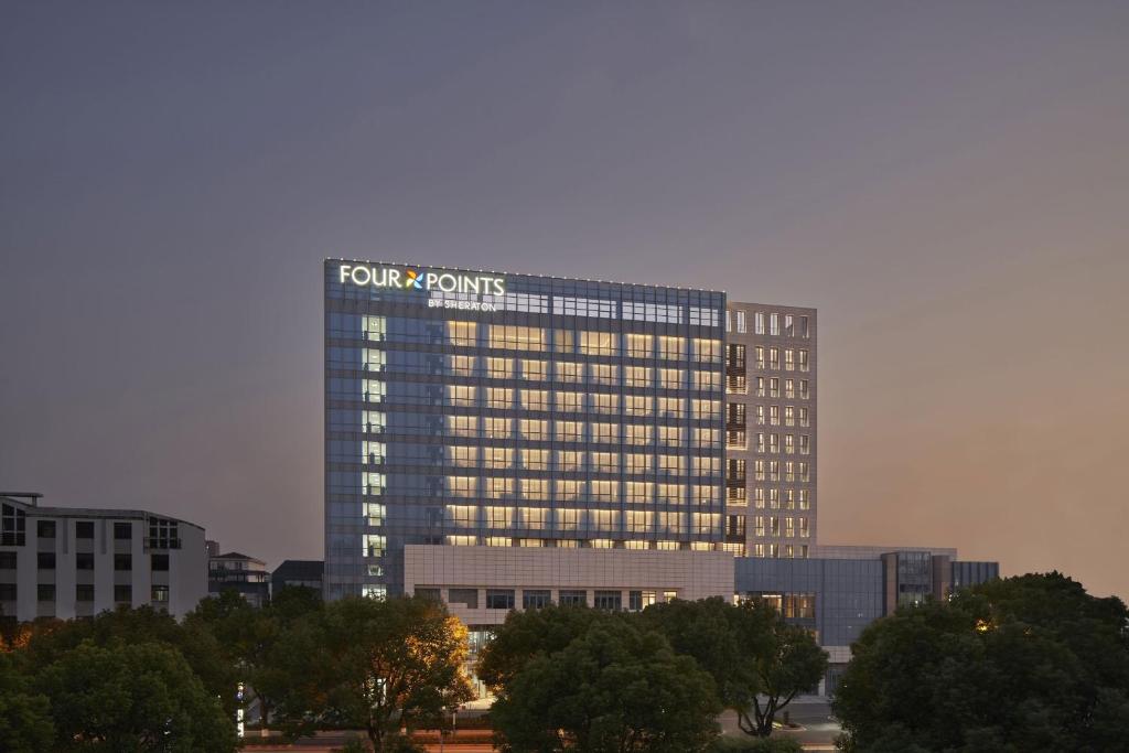 un edificio alto con un cartel encima en Four Points by Sheraton Suzhou, Wuzhong, en Suzhou