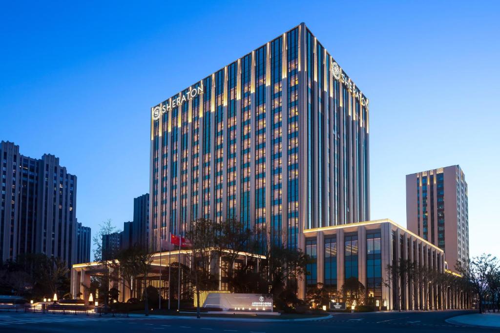 a tall building with lights on in a city at Sheraton Shanghai Fengxian in Shanghai