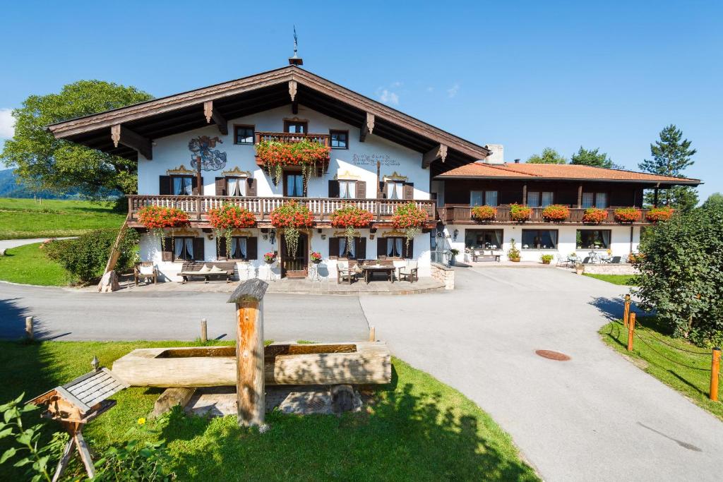 a large building with flowers on the front of it at Gästehaus beim Schneidersepp in Ruhpolding