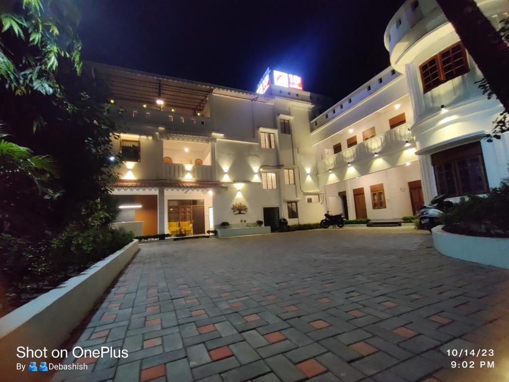 een groot wit gebouw met een oprit 's nachts bij Hotel Insta 18 in Siliguri