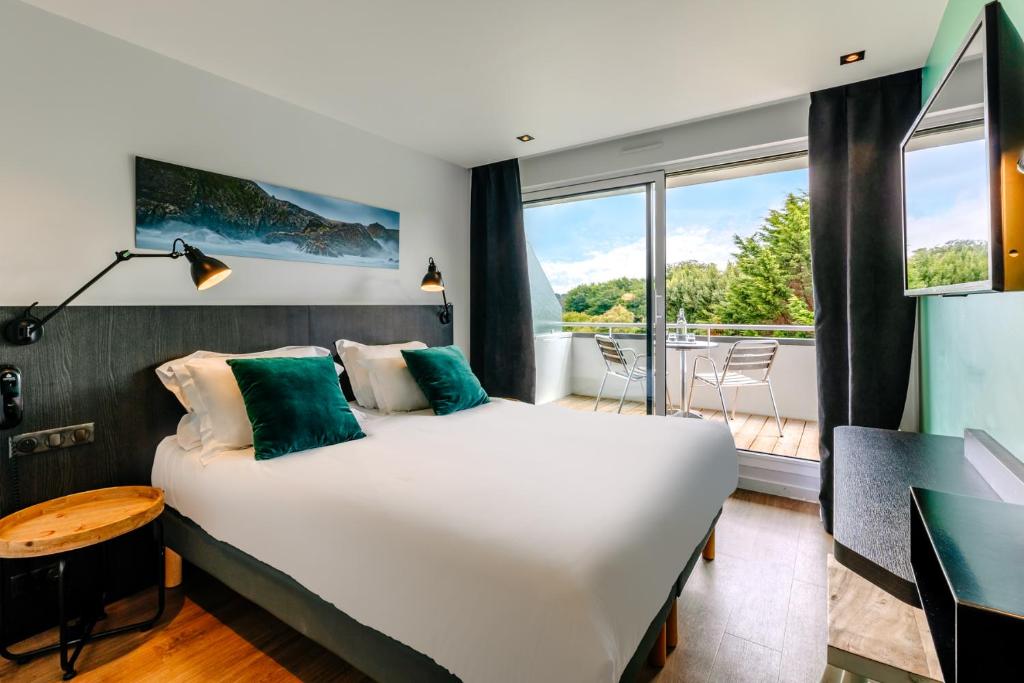 ein Schlafzimmer mit einem großen Bett und einem Balkon in der Unterkunft Le Cardinal - Belle-Ile-en-Mer in Sauzon