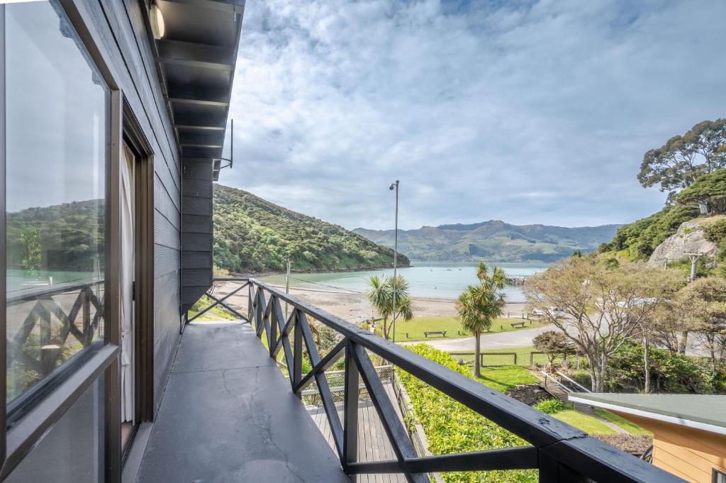 einen Balkon mit Blick auf den Fluss und die Berge in der Unterkunft Bay View - Wainui Holiday Home in Akaroa