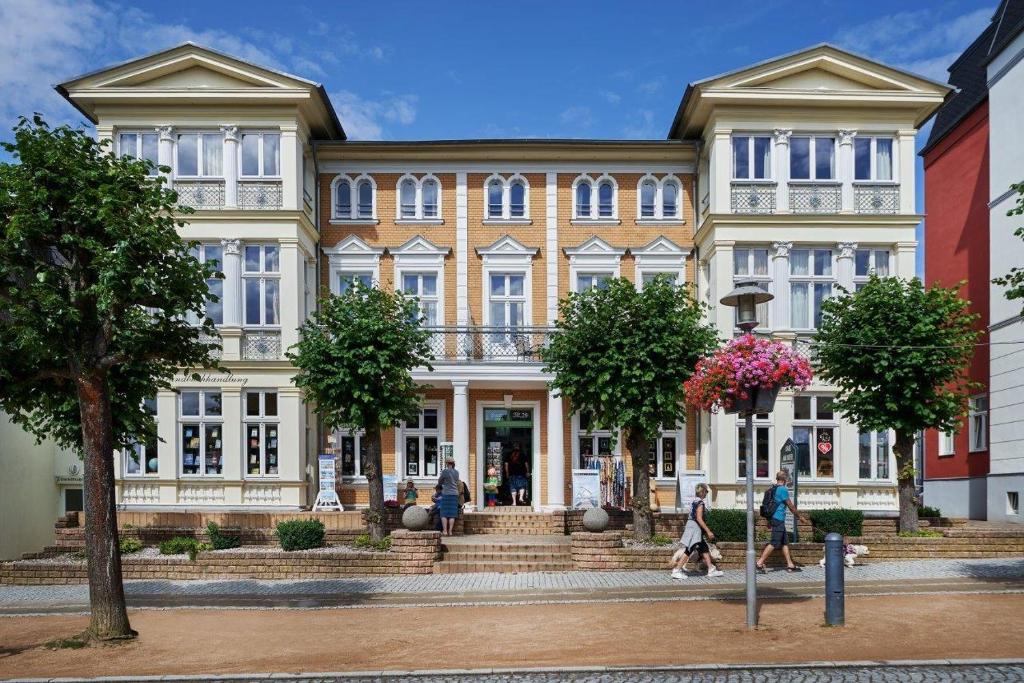 un edificio con gente caminando delante de él en Strandvilla Viktoria - Anbau vom Strandhotel Preussenhof en Zinnowitz