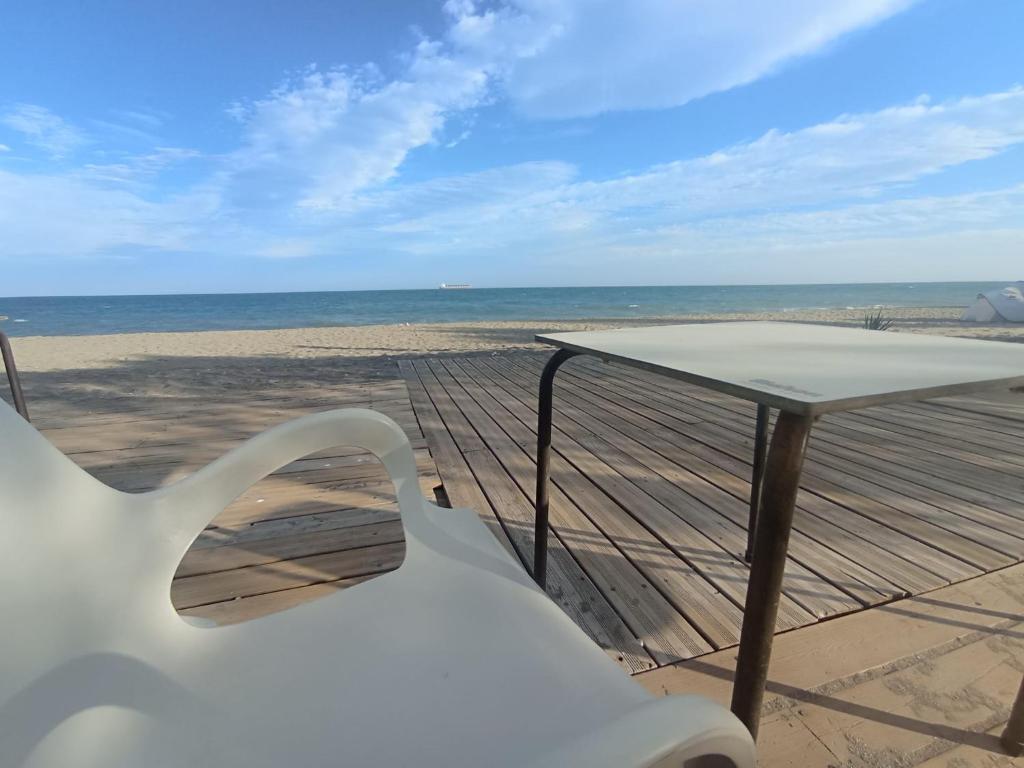 einen weißen Stuhl und einen Tisch am Strand in der Unterkunft SUNRISE Vera-naturista in Vera