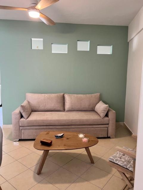 ein Wohnzimmer mit einem Sofa und einem Couchtisch in der Unterkunft Home 4U apt1, just 7km from airport in Markopoulo