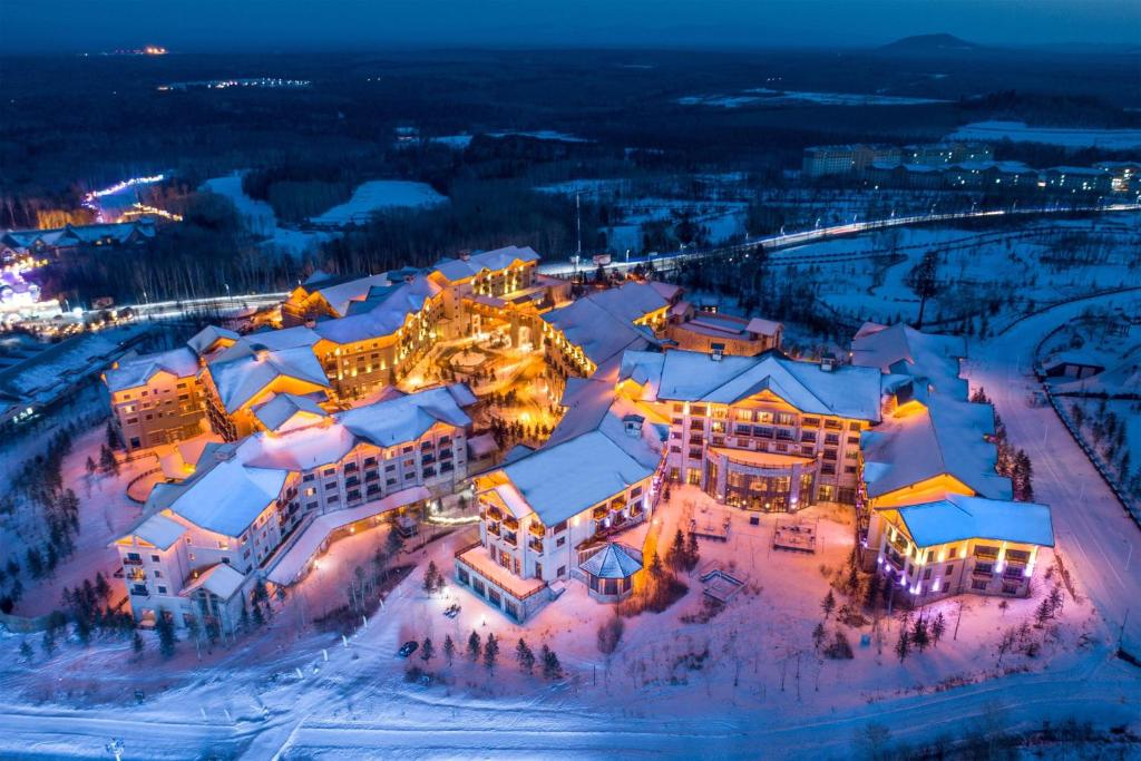 an aerial view of a resort in the snow at night at The Westin Changbaishan Resort in Fusong