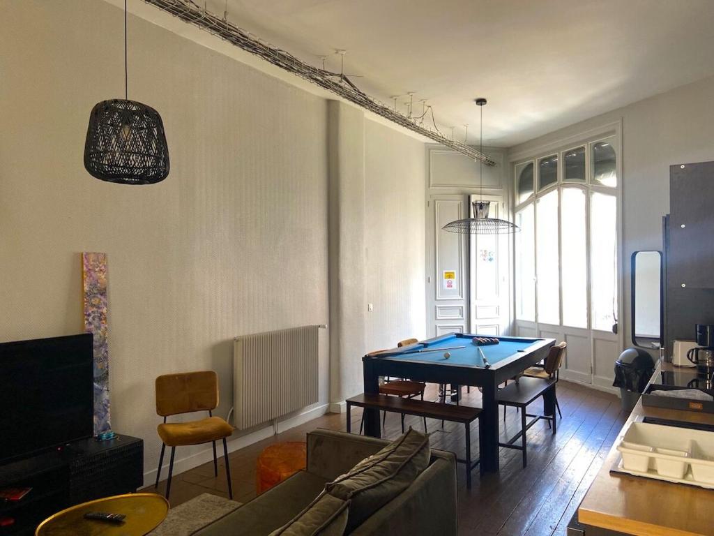 una sala de estar con mesa de ping pong. en Maison standing 9 chambres 5SB avec extérieur, en Roubaix