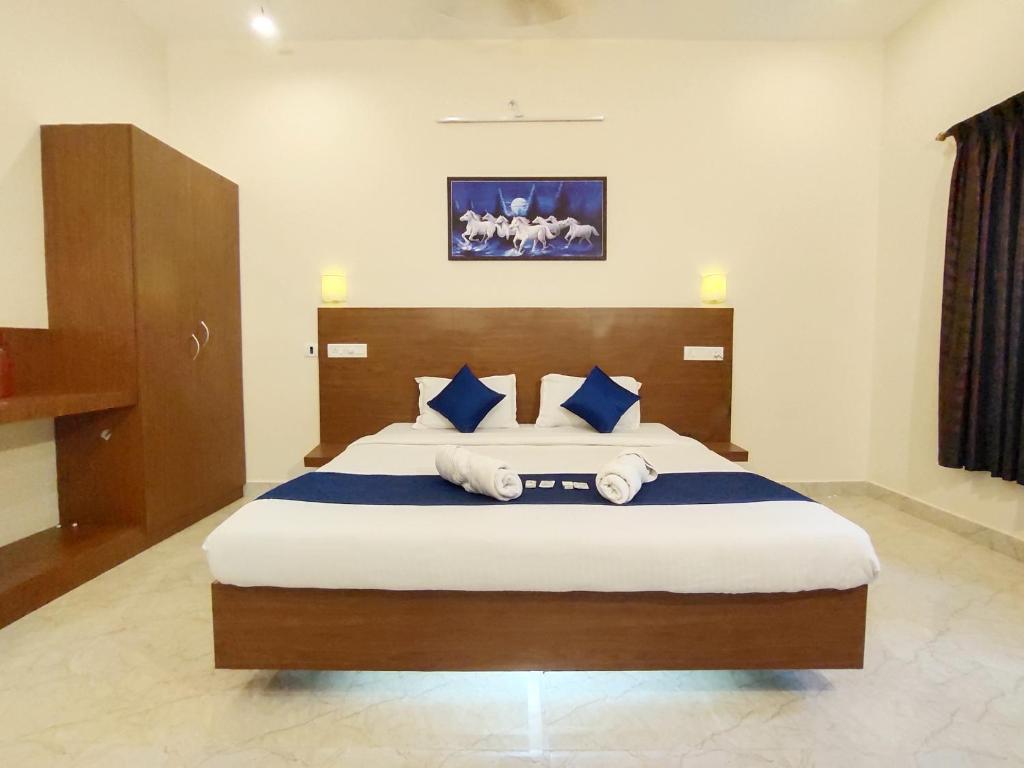 - une chambre dotée d'un grand lit avec des oreillers bleus et blancs dans l'établissement PV Resort - Auro Beach, à Auroville