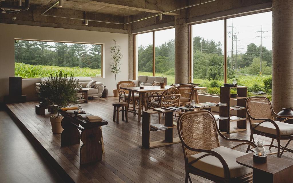 a large room with tables and chairs and windows at Uon in Gyeongju