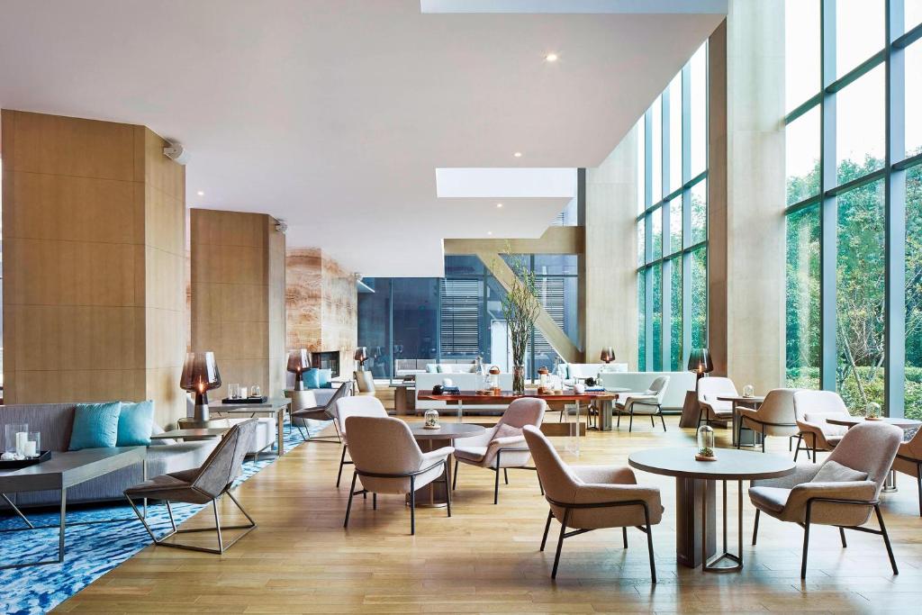 um átrio com mesas, cadeiras e janelas em Hangzhou Marriott Hotel Qianjiang em Hangzhou