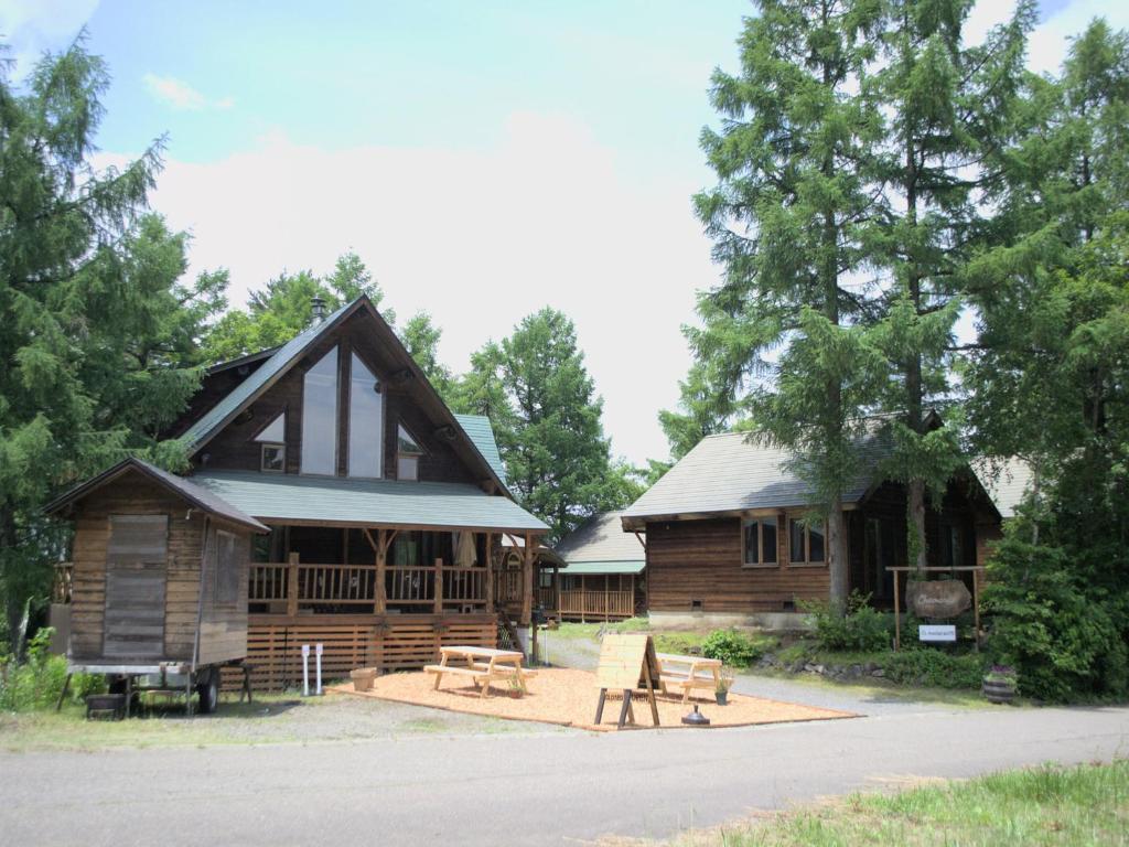 a log cabin with a porch and a house at Madarao Vacance Village in Iiyama