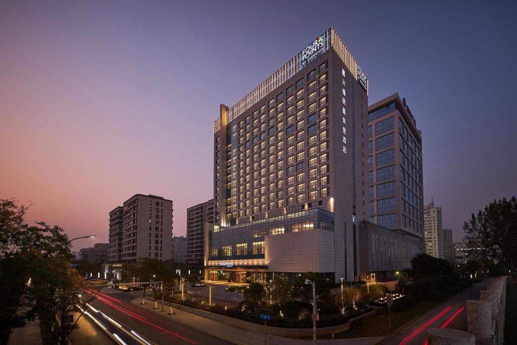 a tall building with a lot of windows in a city at Four Points by Sheraton Jiaxing in Jiaxing