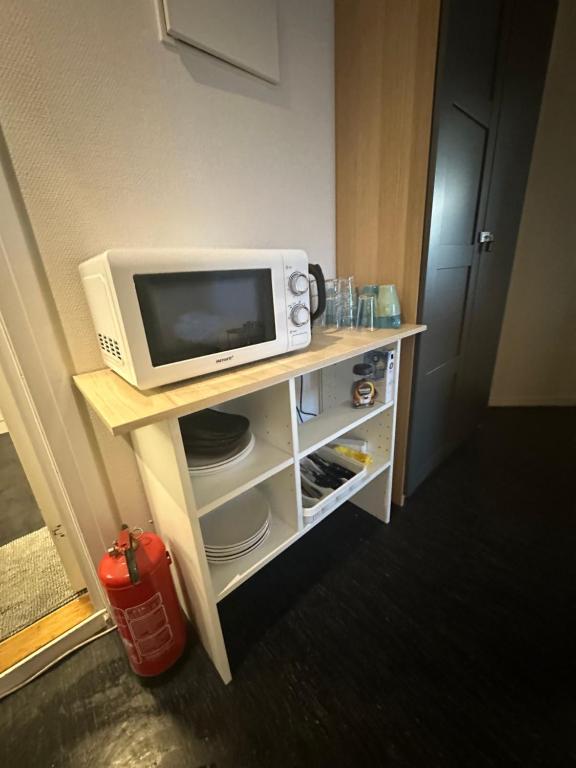 einen TV und eine Mikrowelle auf einem Regal in einem Zimmer in der Unterkunft Center apartments in Oslo