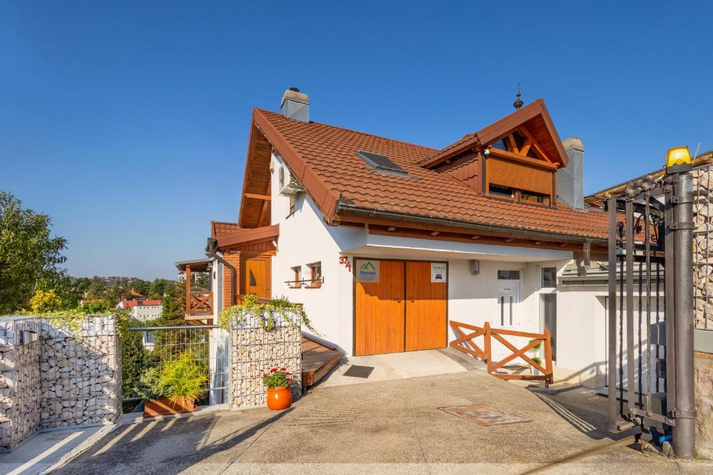 una casa con puertas naranjas y una valla en Vilmos apartman, en Pécs