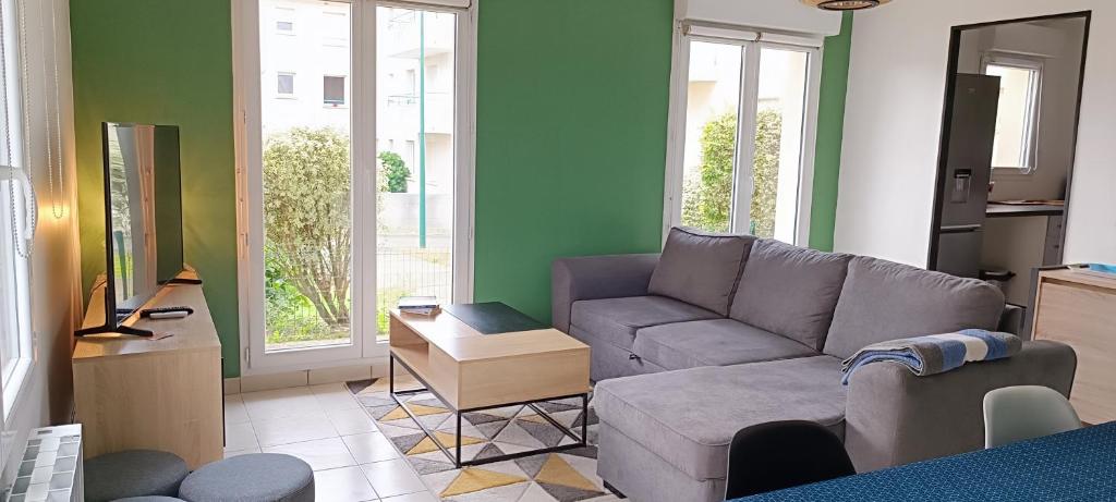 uma sala de estar com um sofá e uma mesa em Appartement calme, à proximité du parc des expos em Quimper
