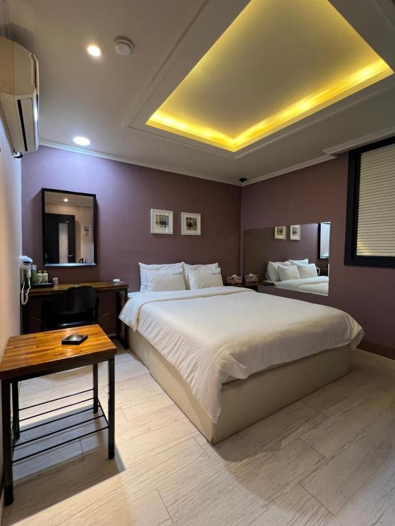a bedroom with a large bed and a table at Jjak motel in Changwon