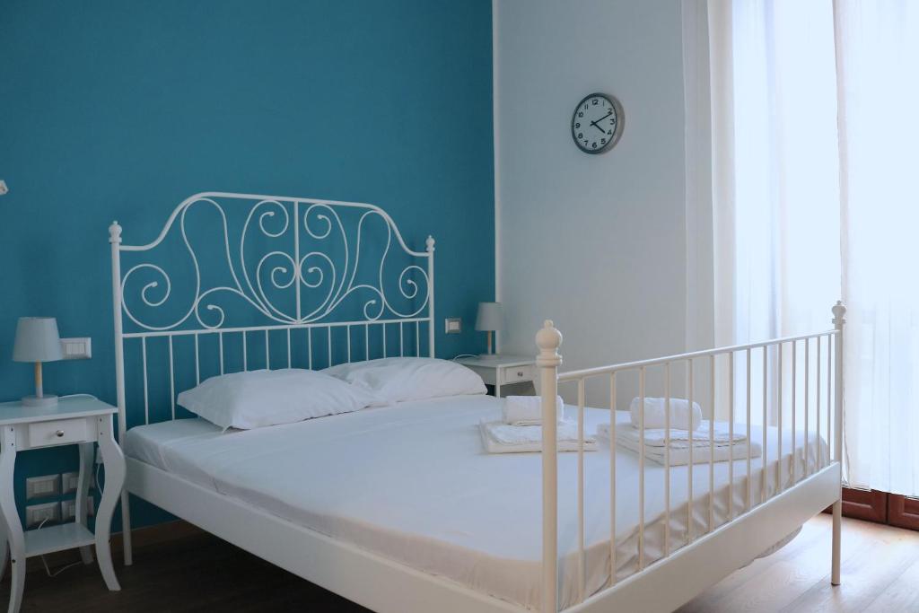 um quarto azul com uma cama e um relógio na parede em Lovely Navigli Studio with balcony - Via Carlo torre em Milão